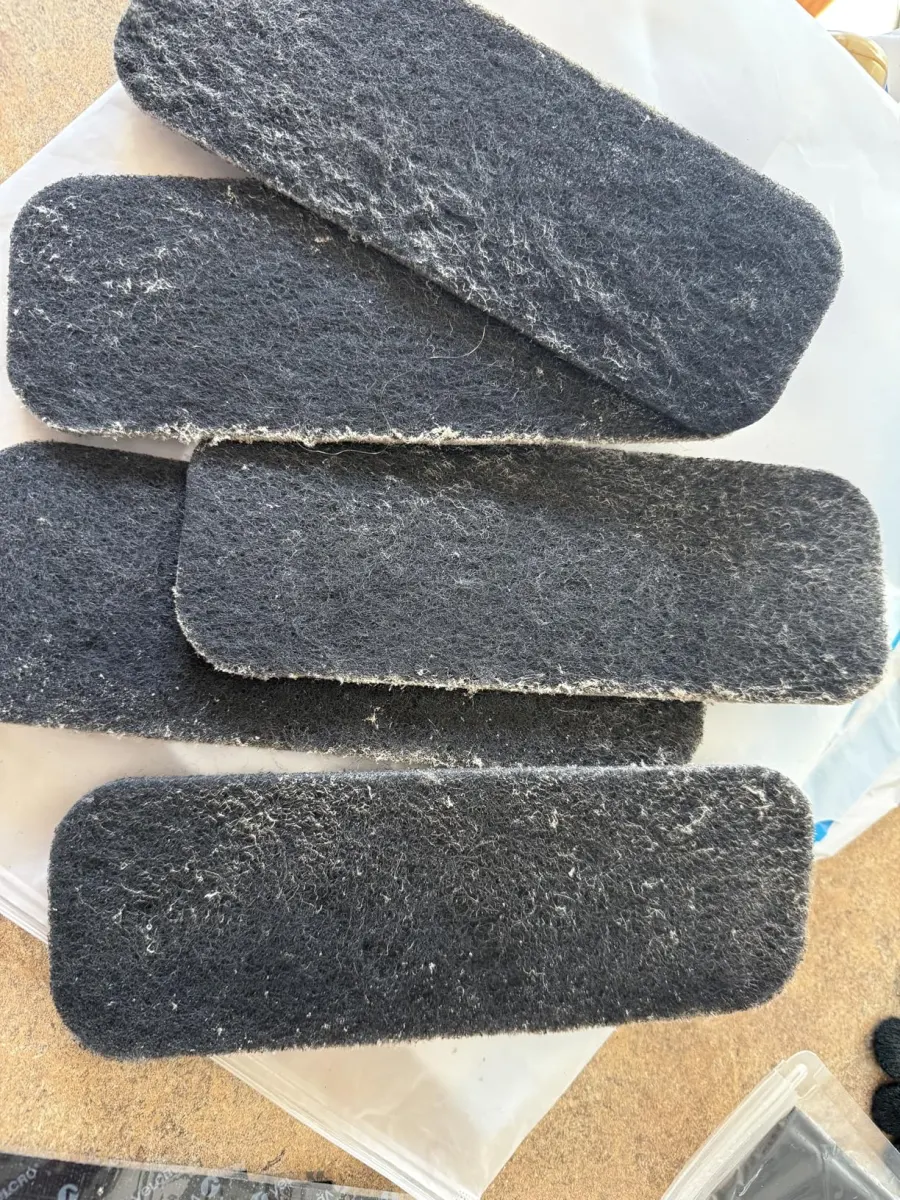 Several used filter pads caked in dust